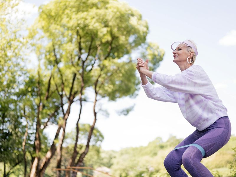 A woman feeling energetic and happy outdoors in a natural setting.